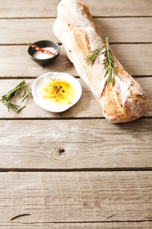 Sliced bread Ciabatta and rosemary on wooden backgroundの写真素材