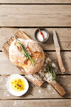 Sliced bread Ciabatta and rosemary on wooden backgroundの写真素材