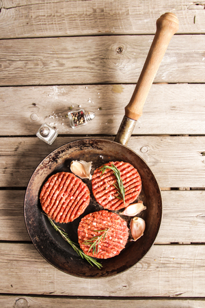 Raw Ground beef meat Burger steak cutlets on  wooden backgroundの写真素材