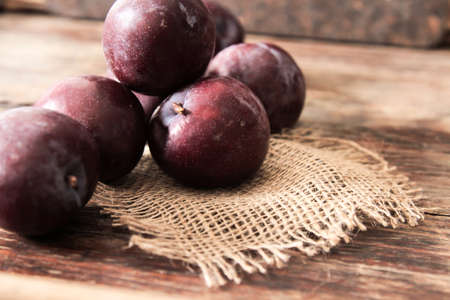plum with blueberries ripe berries to the diet on a wooden backgroundの写真素材