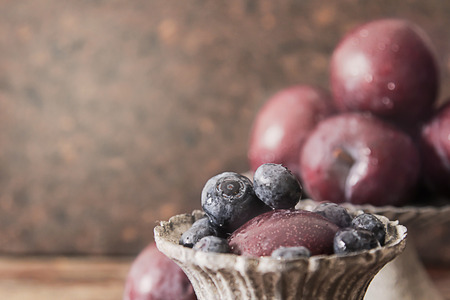 plum with blueberries ripe berries to the diet on a wooden backgroundの写真素材