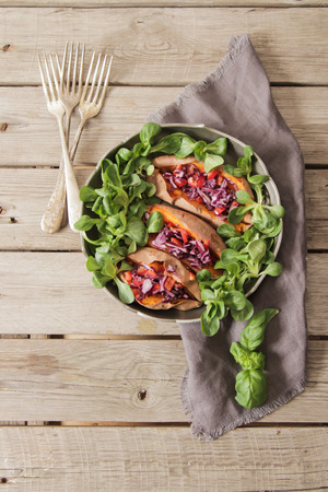 baked sweet potatoes in the oven with carrots and cabbage lettuceの写真素材