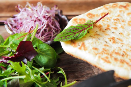 Classic hummus with parsley on the plate and pita salad on a wooden backgroundの写真素材