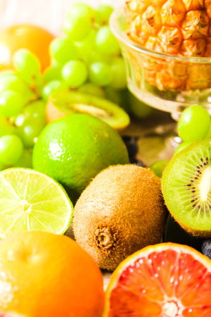 tropical fruit, pineapple, kiwi, lime, red, orange and blueberriesの写真素材