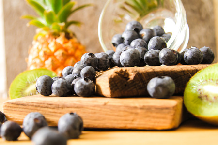 Blueberries in a glass bowl of French with pineapple on  wooden backgroundの写真素材