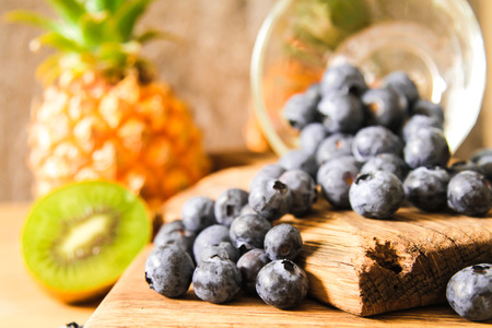 Blueberries in a glass bowl of French with pineapple on  wooden backgroundの写真素材