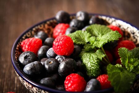 blueberries and raspberries on a plateの写真素材