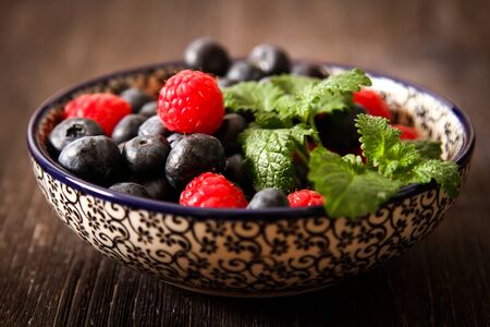 blueberries and raspberries on a plateの写真素材