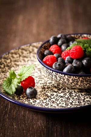 blueberries and raspberries on a plateの写真素材