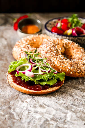 vegan bagel made at home with lettuce and sauce on a stone background