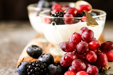 Serving of white Yogurt with Whole Fresh Blueberries  on Old Rustic Wooden Table. Closeup Detail.の写真素材