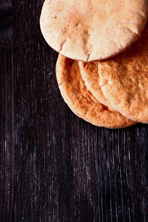 freshly baked pita bread on a wooden table close-up. rolling pin and flour in the backgroundの写真素材