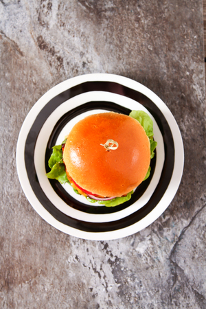 Delicious fresh homemade burger with spicy tomato sauce and beef over light background. Top view, copy space.の写真素材
