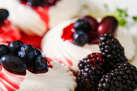 Meringue dessert Pavlova cake with fresh berries on a stone backgroundの写真素材