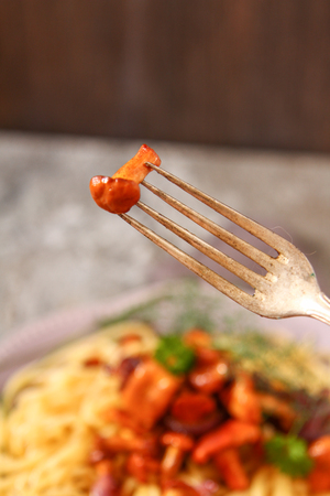 Homemade Italian pasta with chanterelle mushrooms on dark stone background.の写真素材
