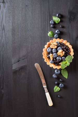 Homemade blueberry tart, walnut and mint on wooden tableの写真素材