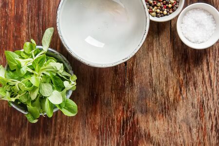 Fresh green salad with salt and pepper. Dark wood backgroundの写真素材