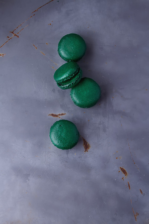 Traditional French sweets. Emerald green macaroon on a metal tray. Gray backgroundの写真素材