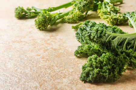 Whole leaves of Italian salad Kare on a stone table with broccoli. Country styleの写真素材