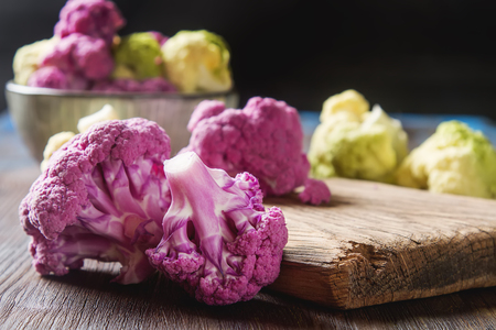 Rainbow of organic cauliflower and Romanesco broccoli on wooden tableの写真素材