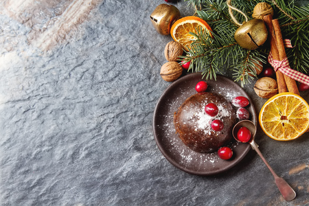 Christmas chocolate pudding with cranberries, walnuts, cinnamon, apples and oranges. Dark backgroundの写真素材
