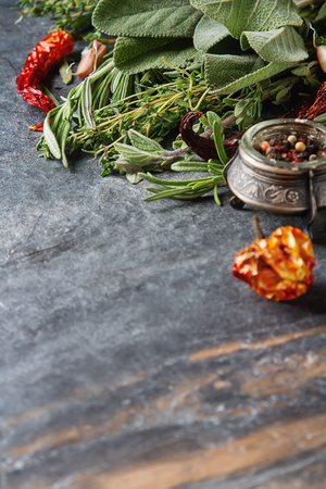 Mix of fresh Italian herbs from garden on an old table. Rosemary, temyan, oregano. Dark background. Dry chiliの写真素材