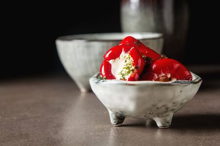 Antipasti Appetizer sweet cherry peppers stuffed with soft cheese feta. Dark backgroundの写真素材