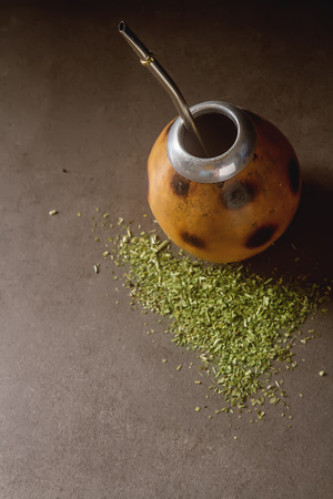 Traditional South American yerba mate tea in the calabash circle and Bombilla. Dark backgroundの写真素材
