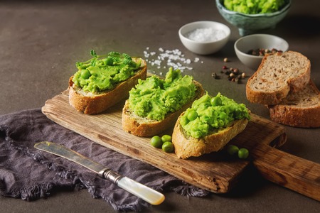 Baguette with mashed green peas and mint. Dark background. Selective focusの写真素材