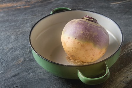 Ripe purple turnips with green leaves. Grey stone backgroundの写真素材