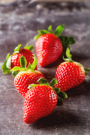 Fresh red strawberry with green leaves. Dark background. Ingredients for smoothiesの写真素材