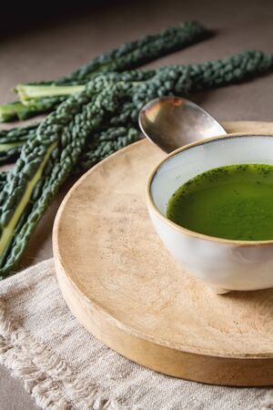 Green Italian soup made from cabbage kale in a white plate. Dark backgroundの写真素材