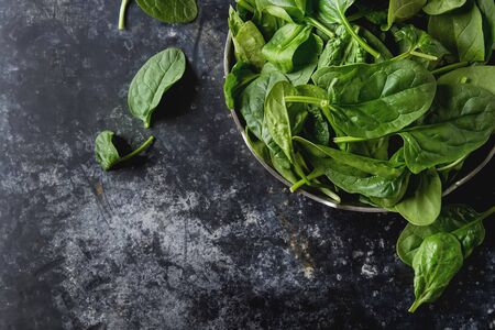 Washed fresh mini spinach on the old concrete table.