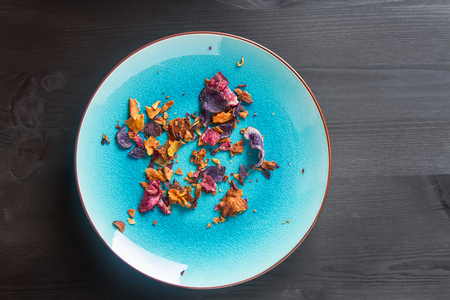 Beet and carrot salty chips in an old blue plate. wood backgroundの写真素材