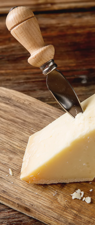 piece of Italian parmesan cheese with a knife.  wood backgroundの写真素材