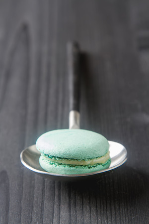Traditional French sweets. Green mint macaroon. Black stone backgroundの写真素材