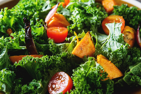 Kale salad sweet potatoes with onions and rosemary. Dark backgroundの写真素材