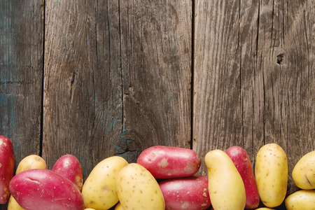 Body multicolored potatoes, Dark background. The farm market. Food for a vegan and a vegetarian. Diet, detox, food conceptの写真素材