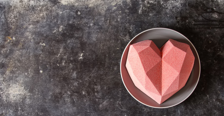 Cake in the form of a pink heart. St. Valentine's Day. Mousse cake. Simple backgroundの写真素材