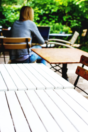 A summer cafe with white wooden tables on the street. Sunny weatherの写真素材