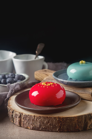 Trendy mousse cake with mirror glaze decorated. Dark backgroundの写真素材