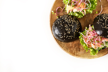 Black burger with salmon fish, lettuce, mustard. Light white background. Fast foodの写真素材