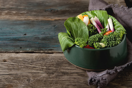 Italian green salad. Broccoli, peppers, tomatoes, onions, bochkoi. Dietary food. Dark backgroundの写真素材