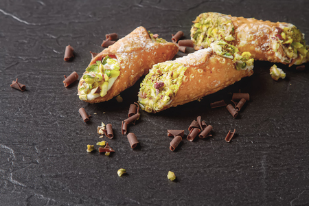 Sweet homemade cannoli stuffed with ricotta cheese cream and pistachial Sicilian dessert. Italian pastry.の写真素材
