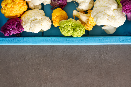 A rainbow of food. Purple cauliflower, orange cauliflower and broccoli, from the local market in London. Food for a vegan and a vegetarian. Dark backgroundの写真素材