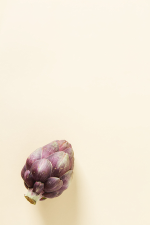 Baby ripping organic Artichokes. Food for a vegan and a vegetarian. Diet, food concept. Multicolored backgroundの写真素材