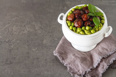 Pea puree with mushrooms in a white ceramic bowl. Delicious vegetarian food. Dark backgroundの写真素材