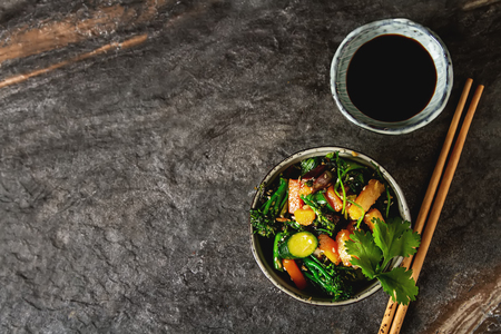 Chinese noodles with vegetables. Melon, onion, beans, broccoli. Food in the wok. Fast food. Dark backgroundの写真素材