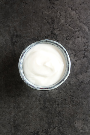 Homemade sour cream in a ceramic bowl. Dark backgroundの写真素材