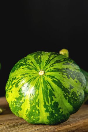 Healthy and delicious green patissons on a wooden board.. dark background. Vegetarian foodの写真素材